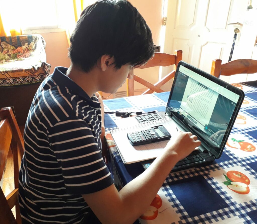 Estudiante con una computadora haciendo la tarea.