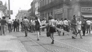 Concentración en calles Mendoza y Mitre de la ciudad de Rosario. La mayoría de los jóvenes son hombres y en primera plano dos mujeres cargando maderas usadas para cortar la calle.