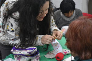 Docente de taller textil explicando una técnica.