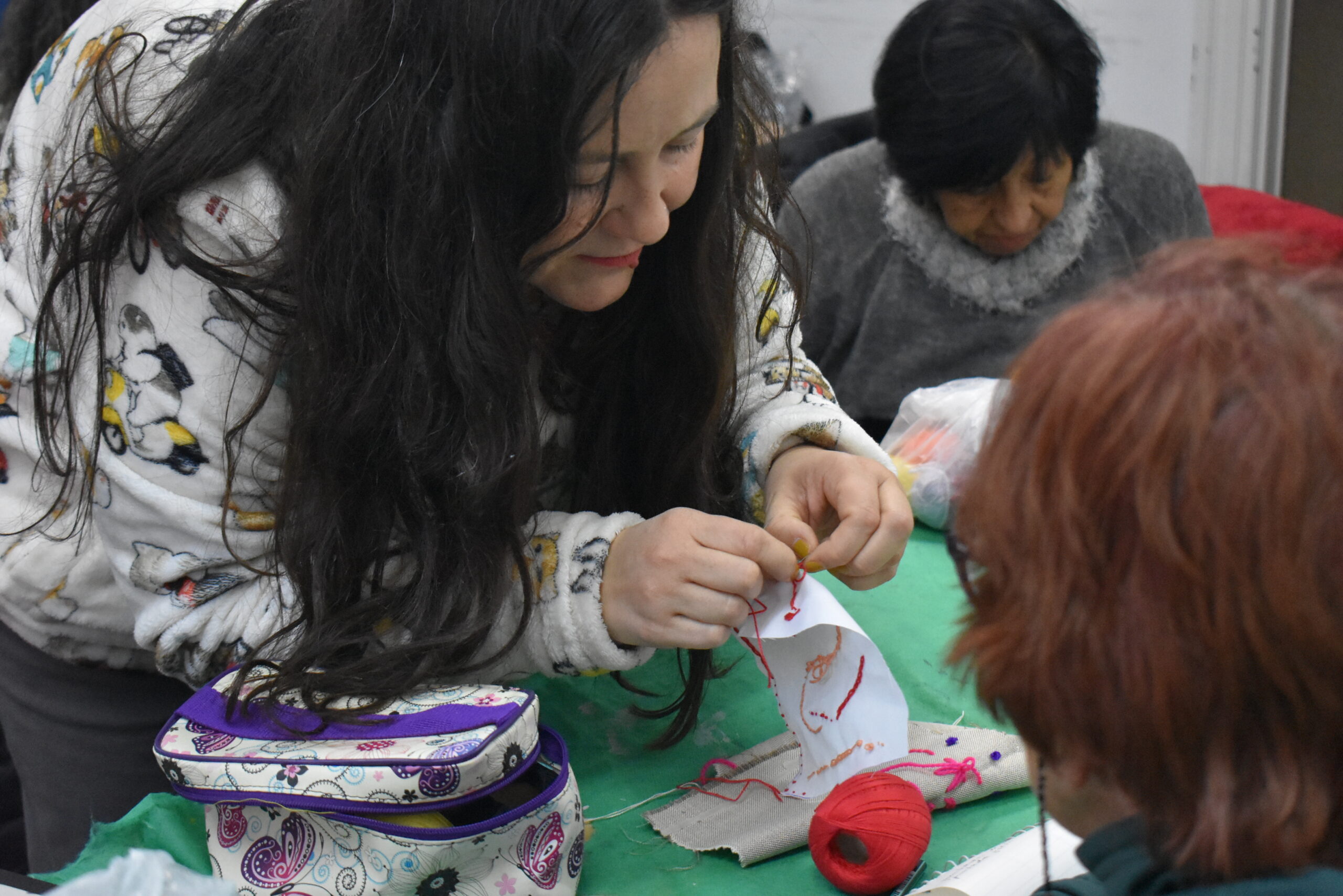 Docente de taller textil explicando una técnica.